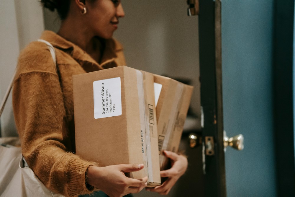 A woman bringing packages into a house