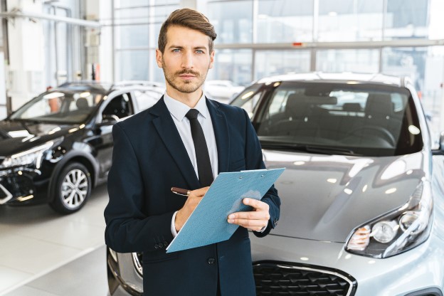 A man selling cars at a car dealership