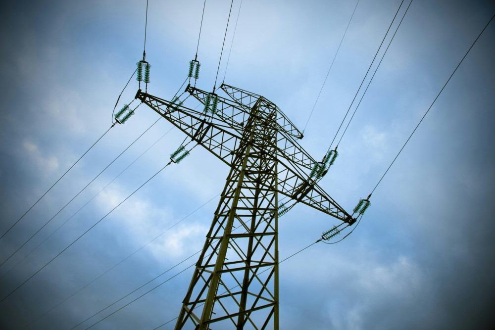 An electrical tower in front of cloudy sky