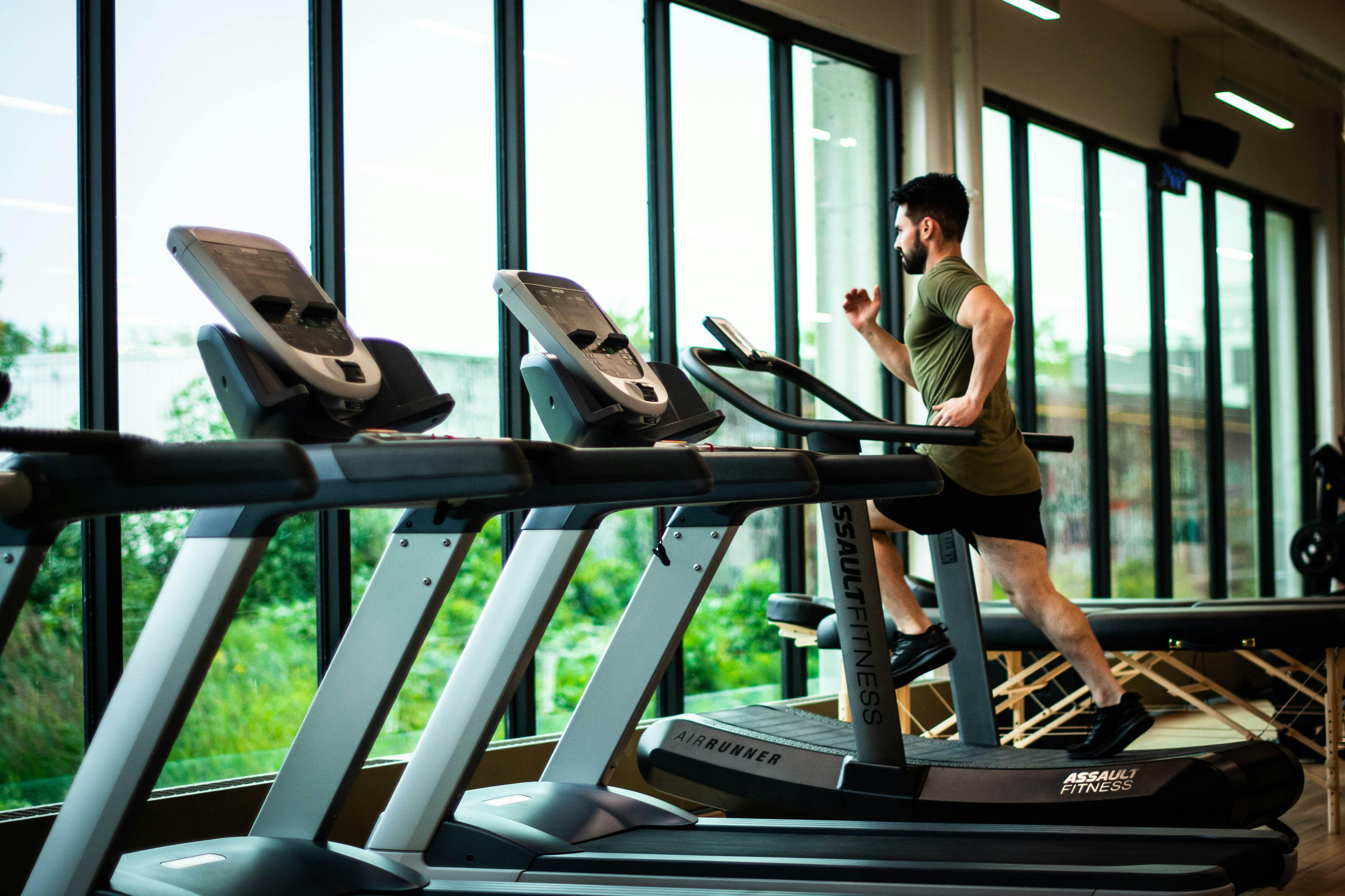 A man running on a treadmill inside a gym