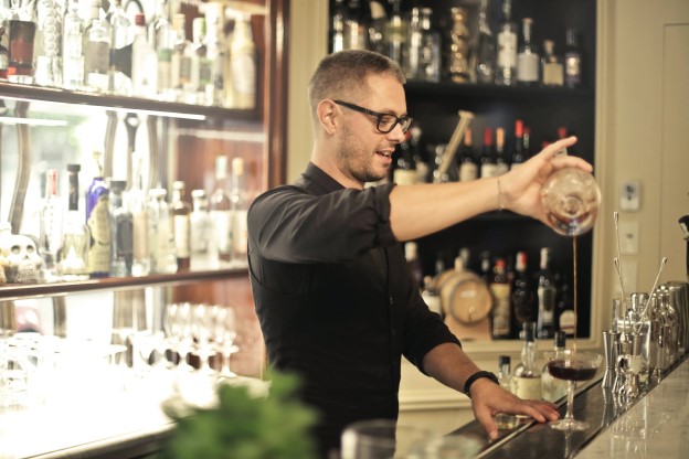 A bartender making drinks for customers