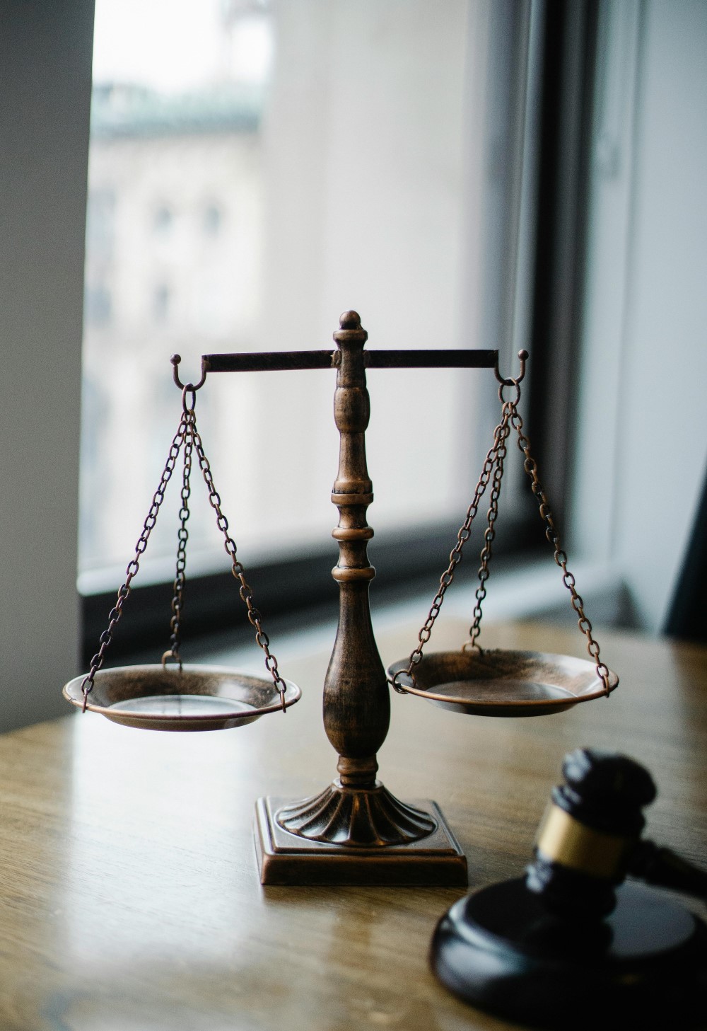 A table containing an in focus scale behind a blurred gavel