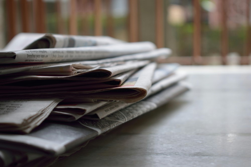 A stack of newspapers and magazines on a table